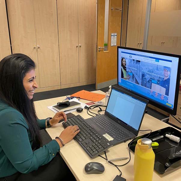 ILG employee working on laptop while also looking at the ILG website
