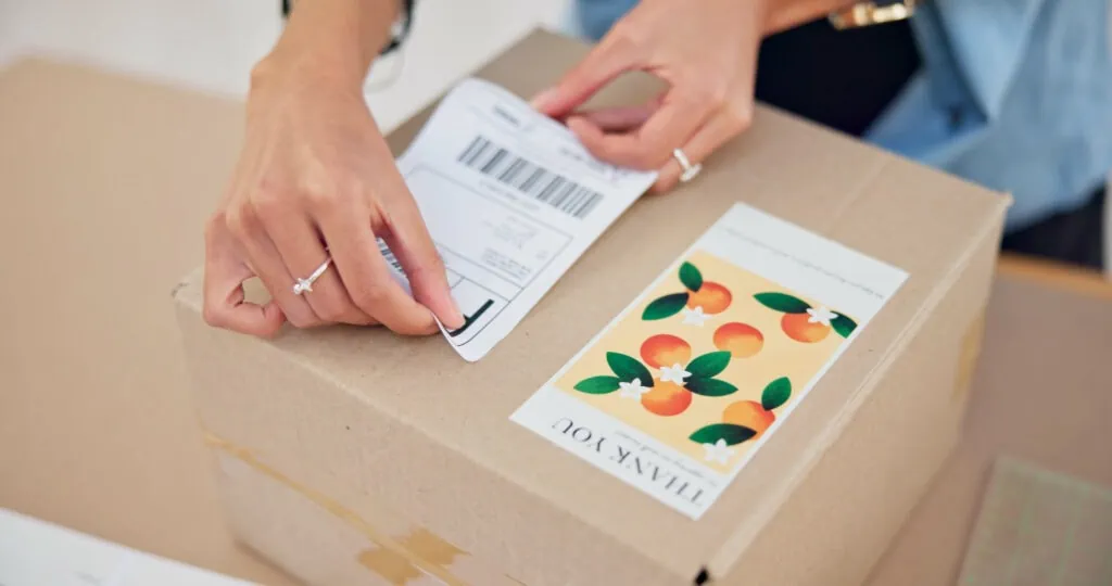 Woman placing address label on parcel