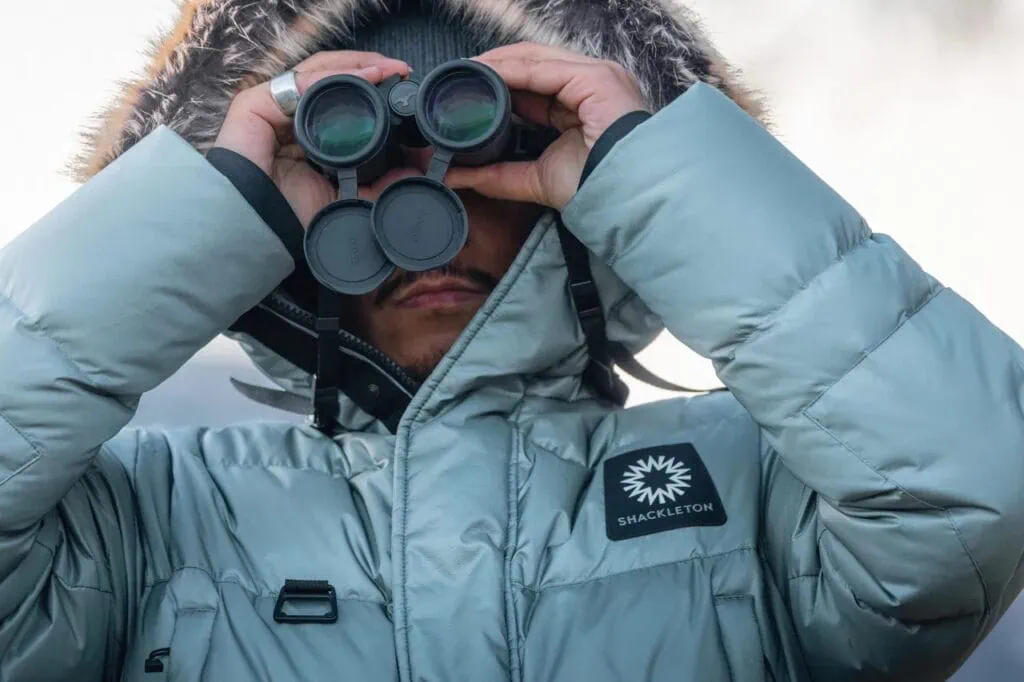 Man looking through binoculars in Shackleton coat
