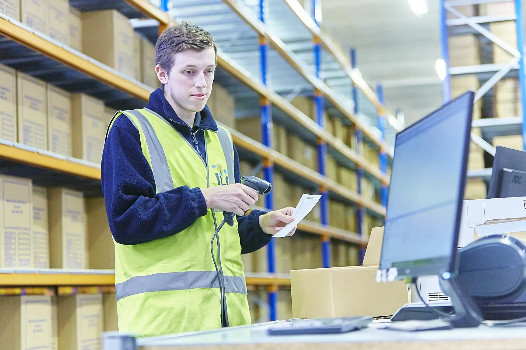 ILG employee scans paper with a barcode scanner whilst looking at computer screen