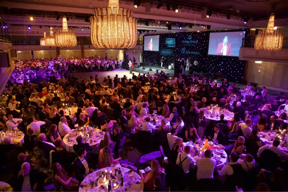 a busy awards ceremony showing the tables and stage