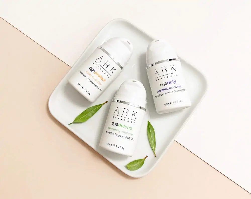 Ark Skincare moisturizers on a plate with leaves