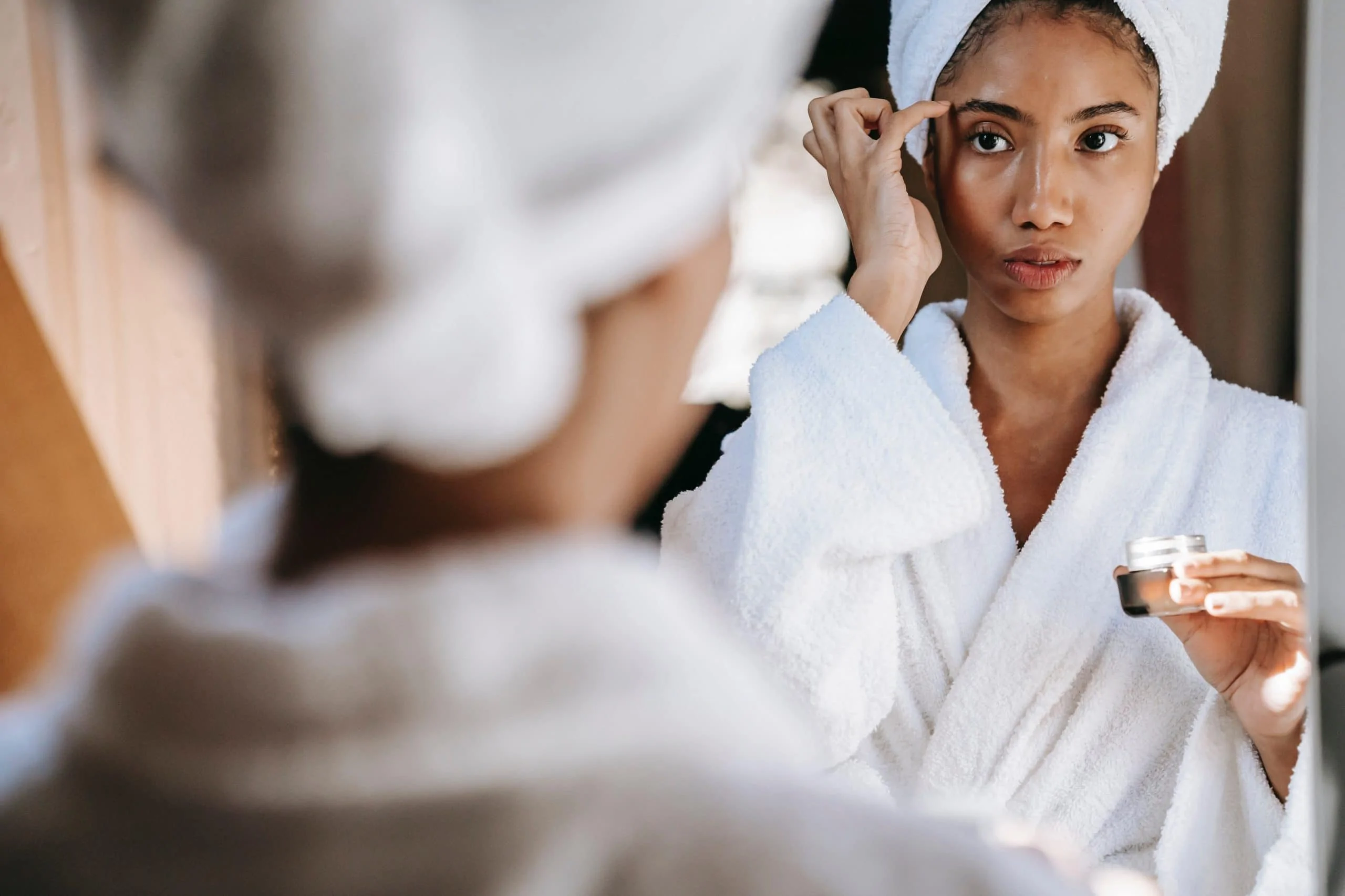 Woman in bathroom using face cream