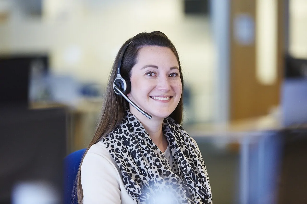 ILG Client Service team member sitting at desk smiling