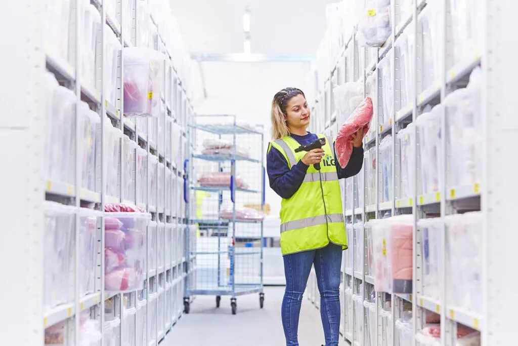 Woman scanning fashion item on racking