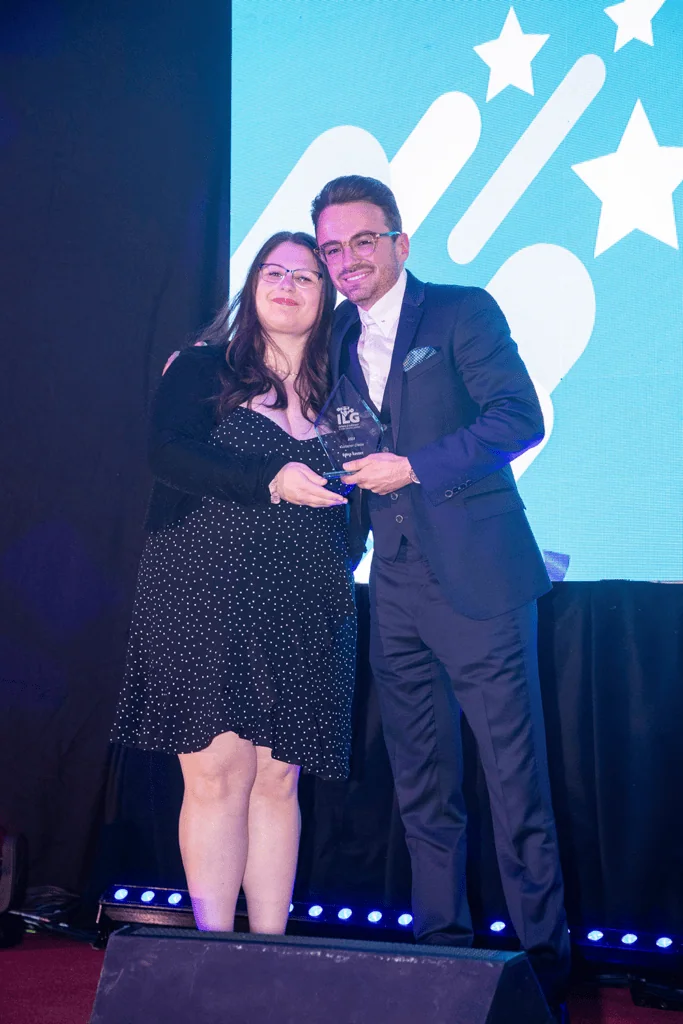 Edina accepting award from Tom Ashley on stage