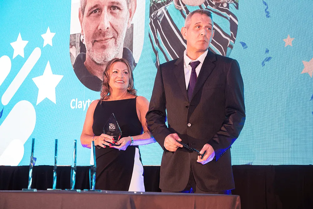 Jo and Clayton accepting award on stage