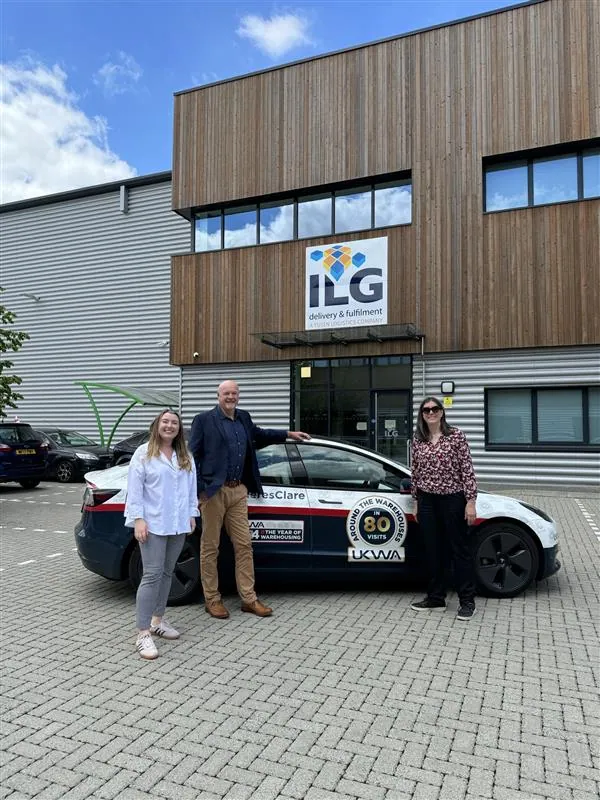 Clare Bottle and ILG staff stand outside Salfords warehouse with car branded in UKWA branding