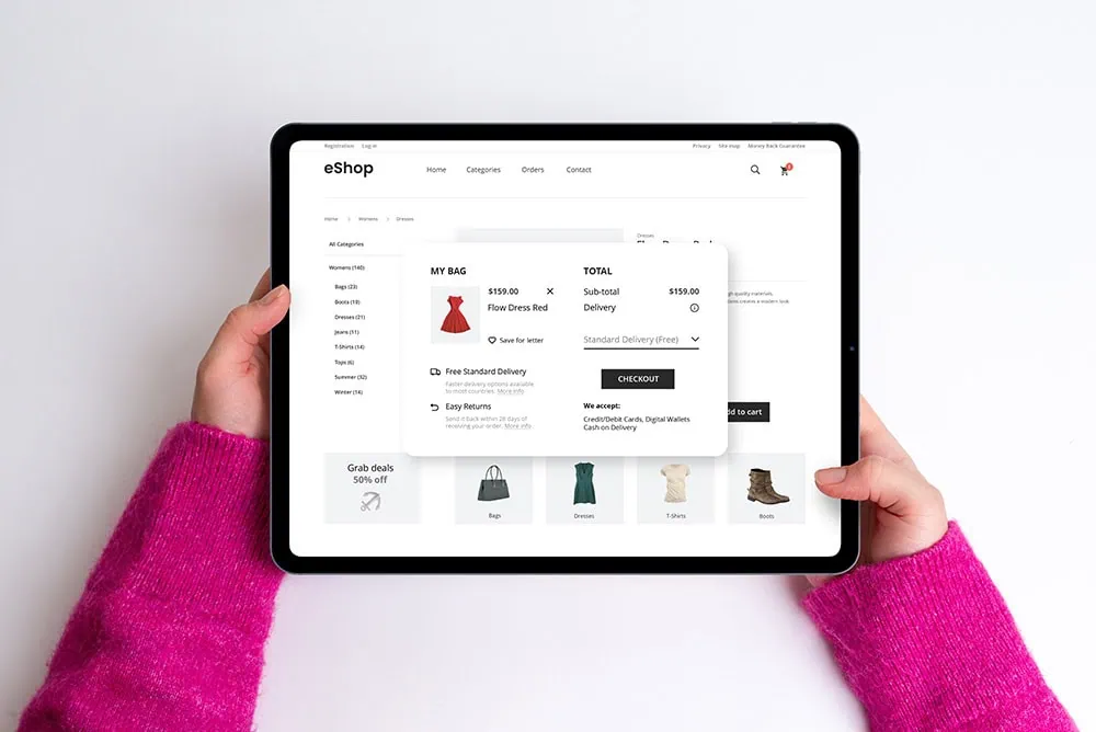 Hands holding a tablet showing the checkout page of an e-commerce website