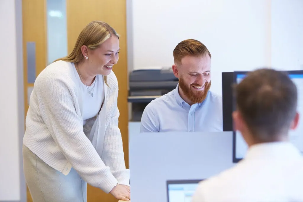 two people laughing at desk