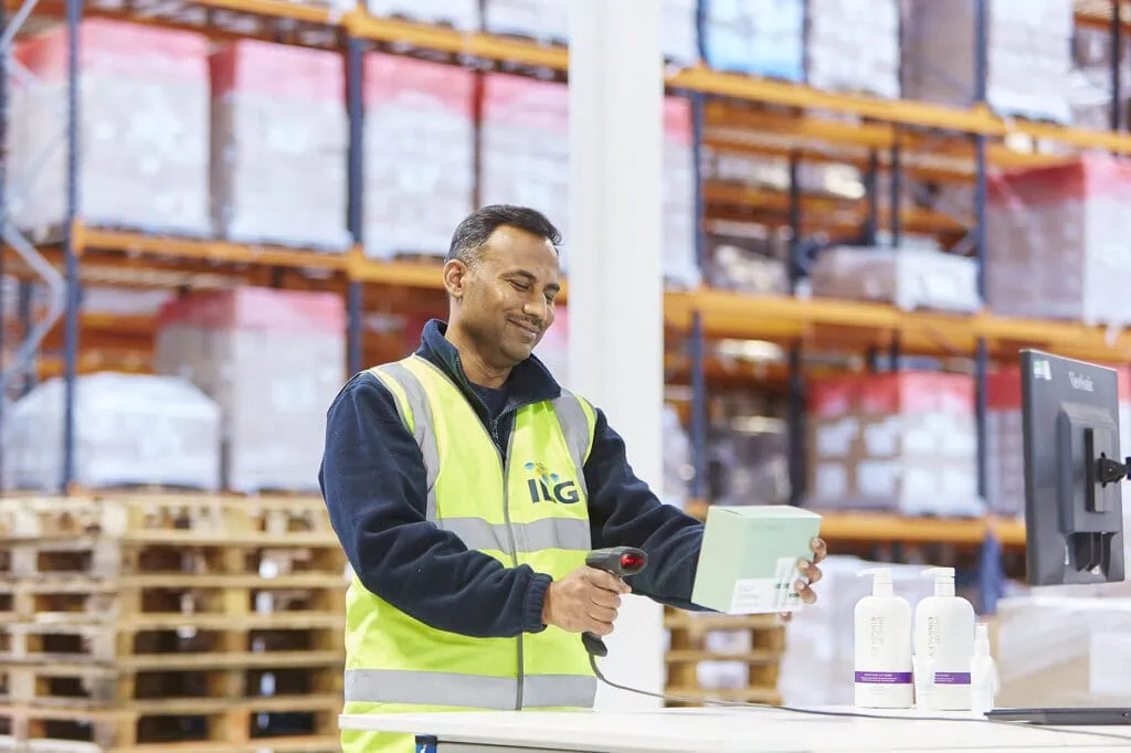 man scanning haircare products in warehouse