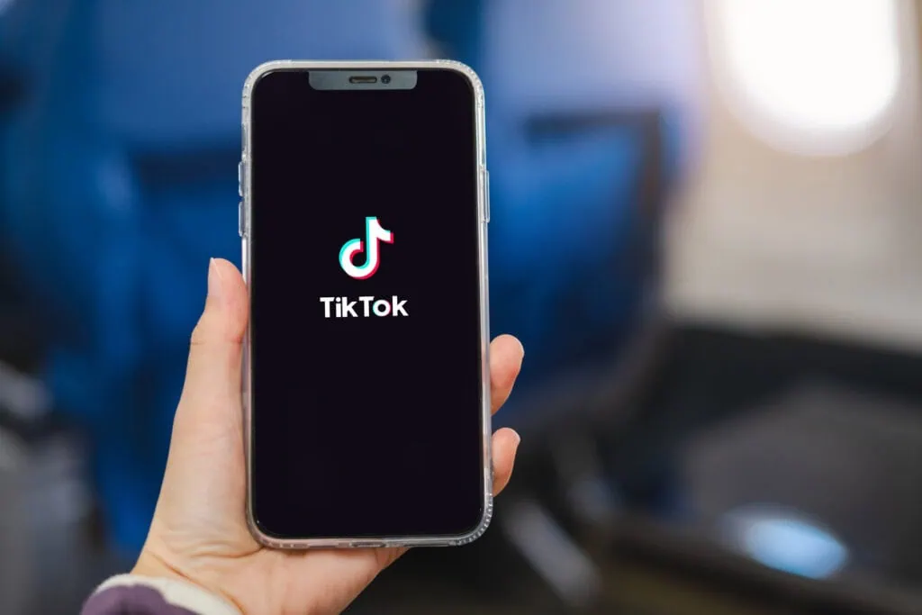 Hands holding an iPhone with tiktok logo